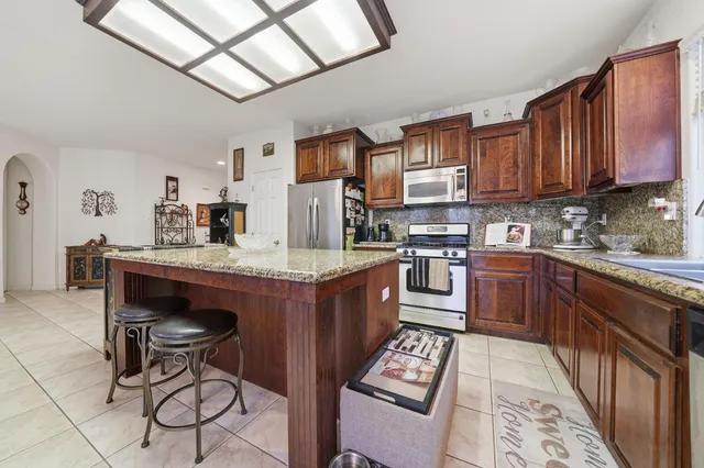 a kitchen with stainless steel appliances granite countertop a refrigerator a stove a sink and dishwasher