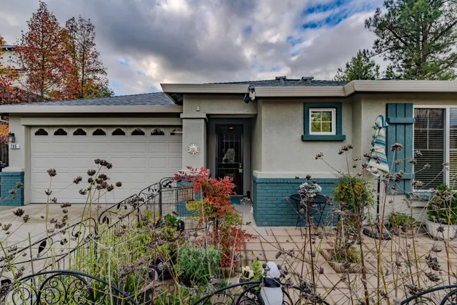 a view of sign board with flower plants and wooden fence