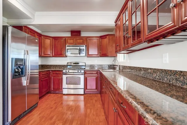 an empty room with wooden floor closet and windows
