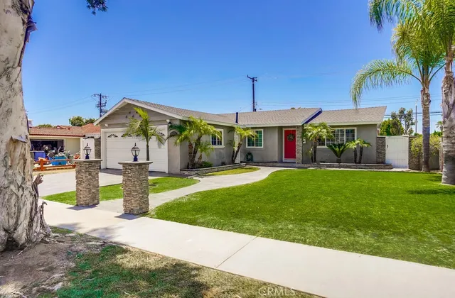 a front view of a house with a yard and potted plants