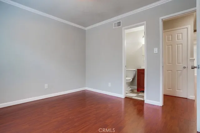a view of a livingroom with wooden floor and a flat screen tv
