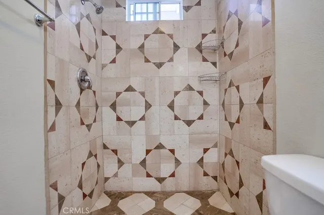 an empty room with wooden floor cabinet and windows