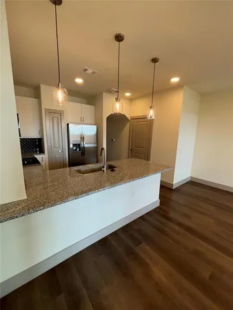 a large kitchen with kitchen island a counter space a sink and a wooden floor