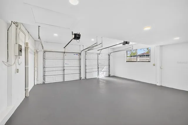 a view of a swimming pool with a lawn chairs under palm trees