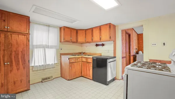 a view of kitchen with refrigerator cabinets and wooden floor
