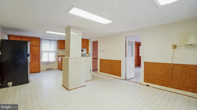 a view of kitchen with refrigerator cabinets and wooden floor