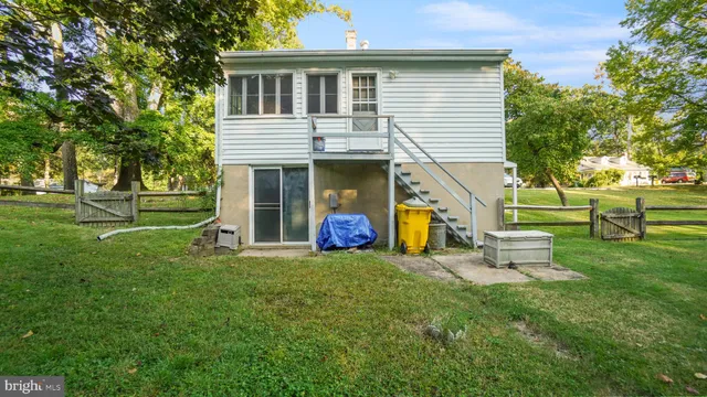 a view of a house with a yard and a large tree