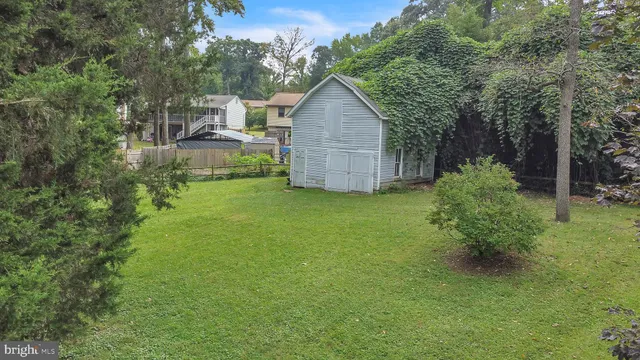 a view of a backyard with barn and large trees