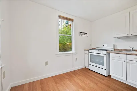 a kitchen with a white cabinets and wooden floor