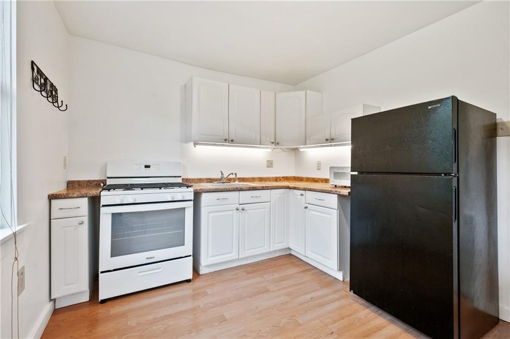 701 Maple Way Oakmont, PA 15139 - Photo 5 of 26 a kitchen with a refrigerator and a stove top oven