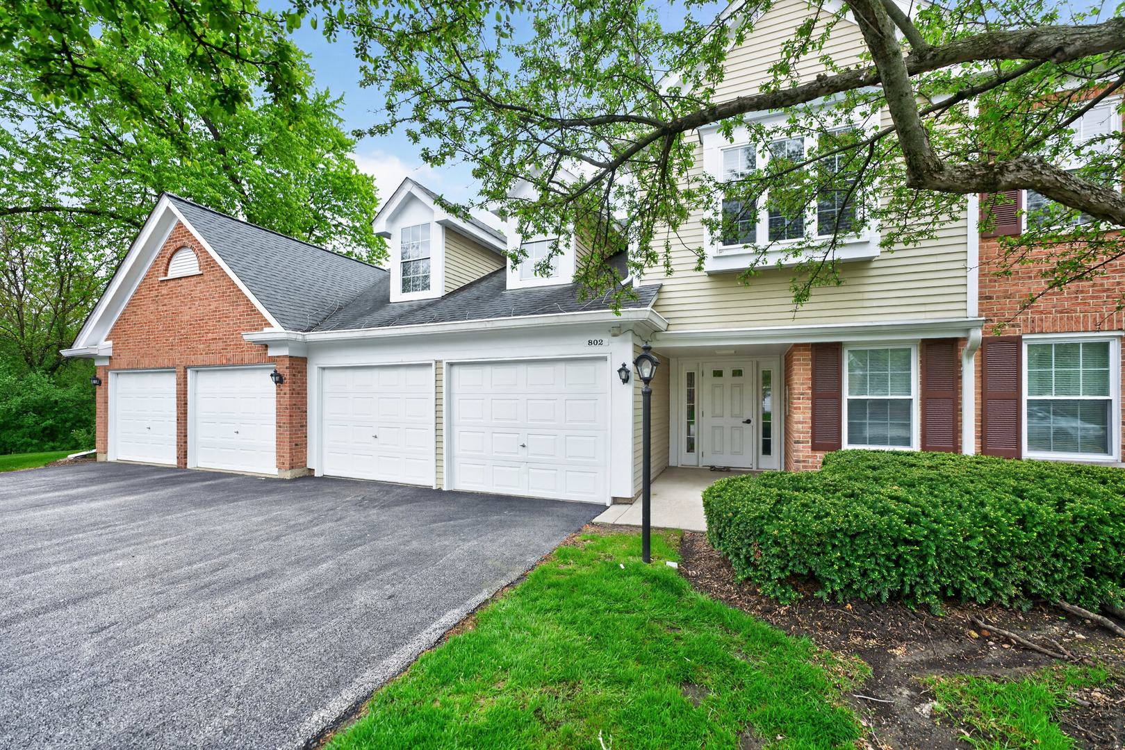 802 Butternut Lane, Unit C Mount Prospect, IL 60056 - Photo 1 of 36 a front view of a house with a garden and trees