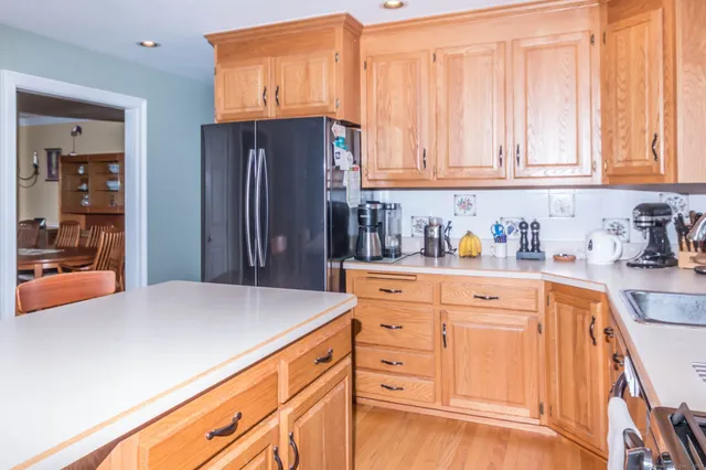 a kitchen with granite countertop white cabinets and refrigerator