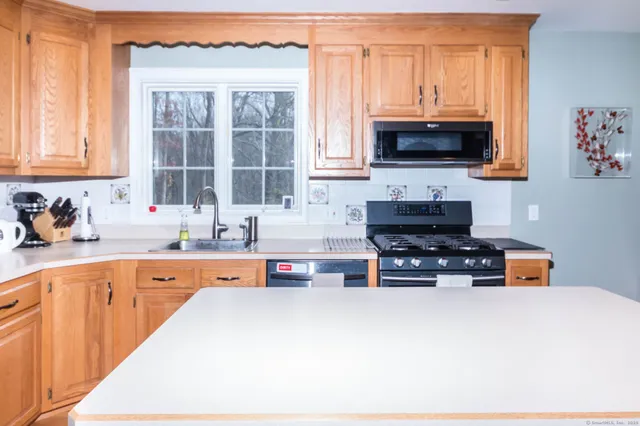 a kitchen with stainless steel appliances a sink a stove and a microwave