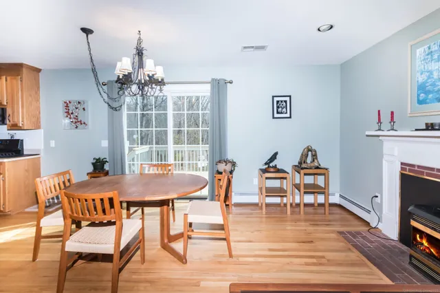 a dining room with furniture a chandelier and wooden floor