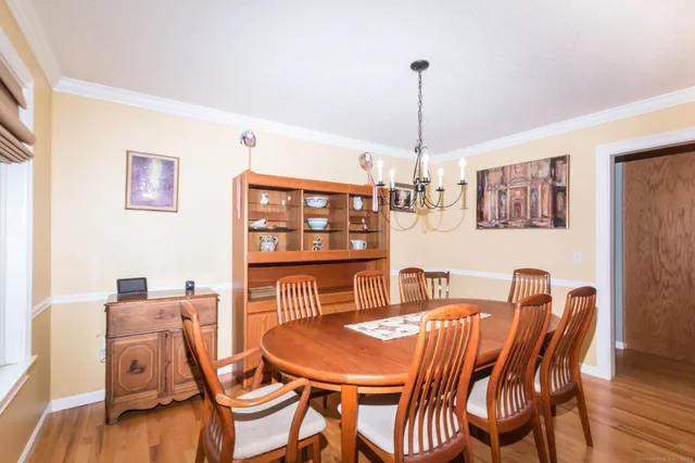 a dining room with furniture a chandelier and wooden floor