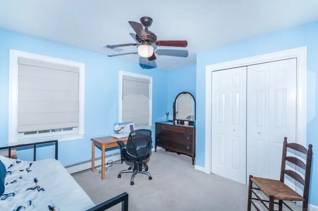 a workspace with chandelier fan and a window