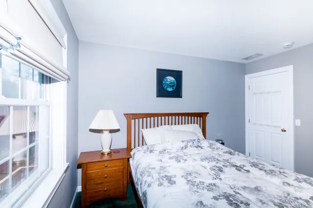a bedroom with a bed and a lamp on table
