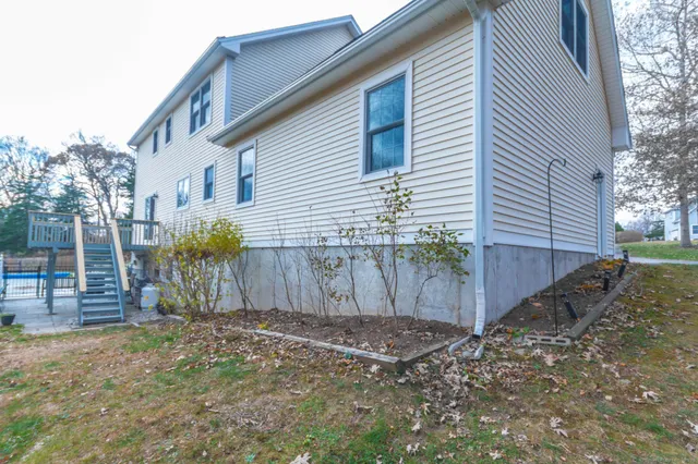 a view of a house with backyard and trees
