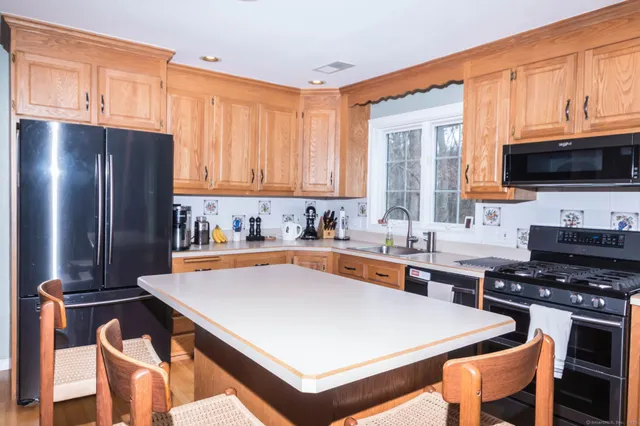 a kitchen with stainless steel appliances a stove a sink a microwave and a refrigerator