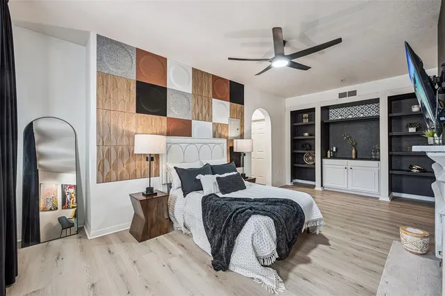 a large bedroom with a bed and wooden floor