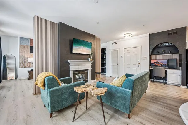 a living room with furniture a fireplace and a flat screen tv