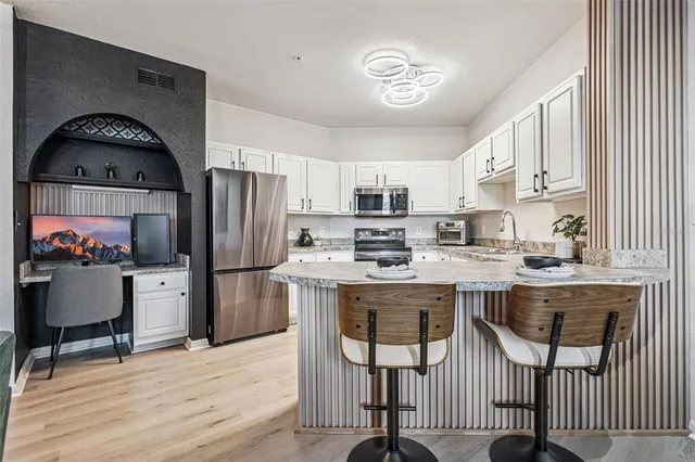 a kitchen with a refrigerator a stove cabinets and a dining table