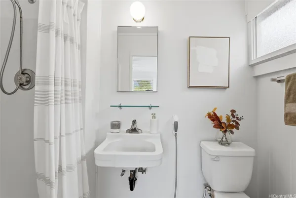 a bathroom with a sink mirror and toilet