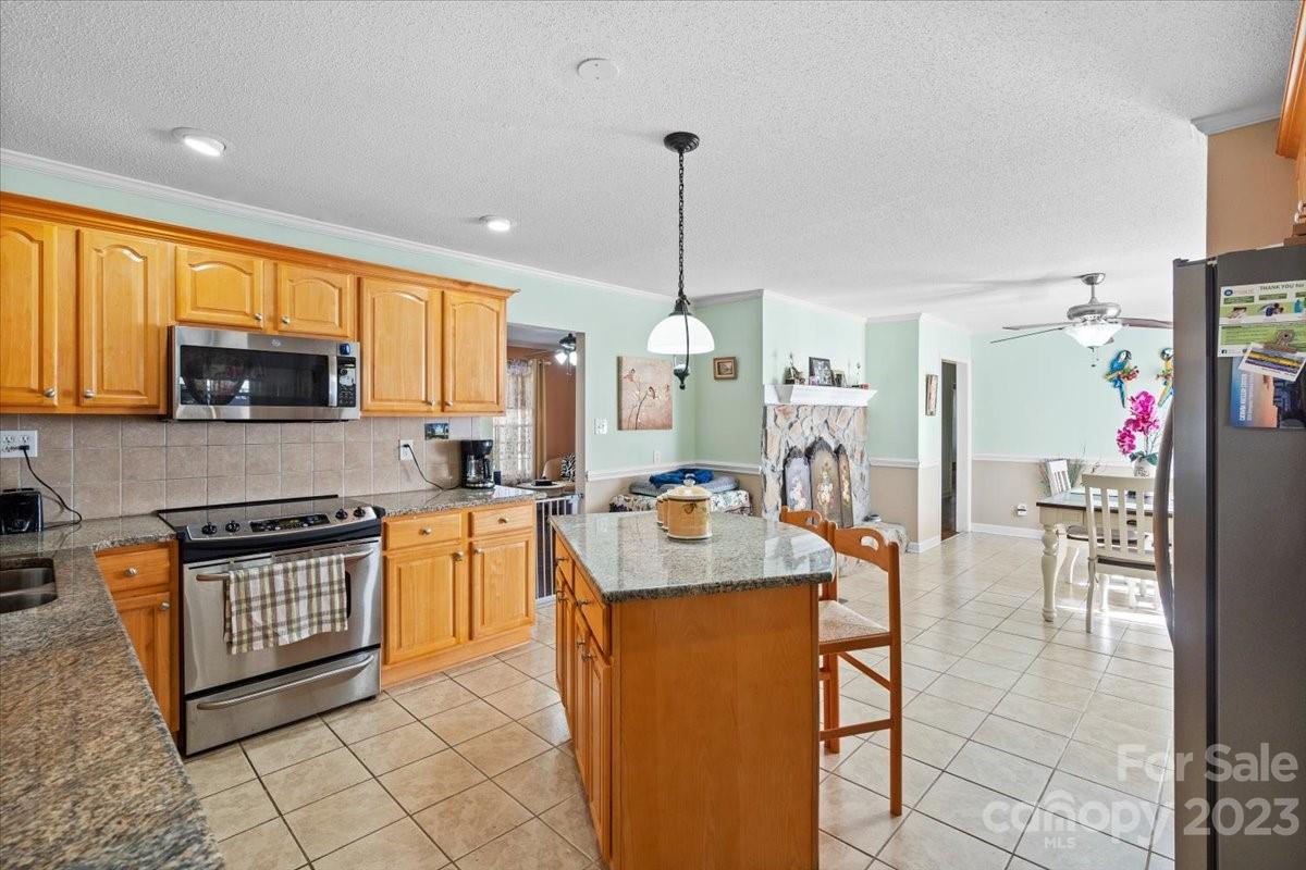 1429 Ebinport Road Rock Hill, SC 29732 - Photo 11 of 30 a kitchen with stainless steel appliances granite countertop a sink dishwasher a stove a refrigerator oven and a dining table with wooden cabinet