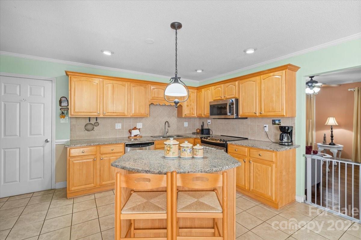 1429 Ebinport Road Rock Hill, SC 29732 - Photo 8 of 30 a kitchen with stainless steel appliances granite countertop a stove top oven a sink a dining table and chairs with wooden floor