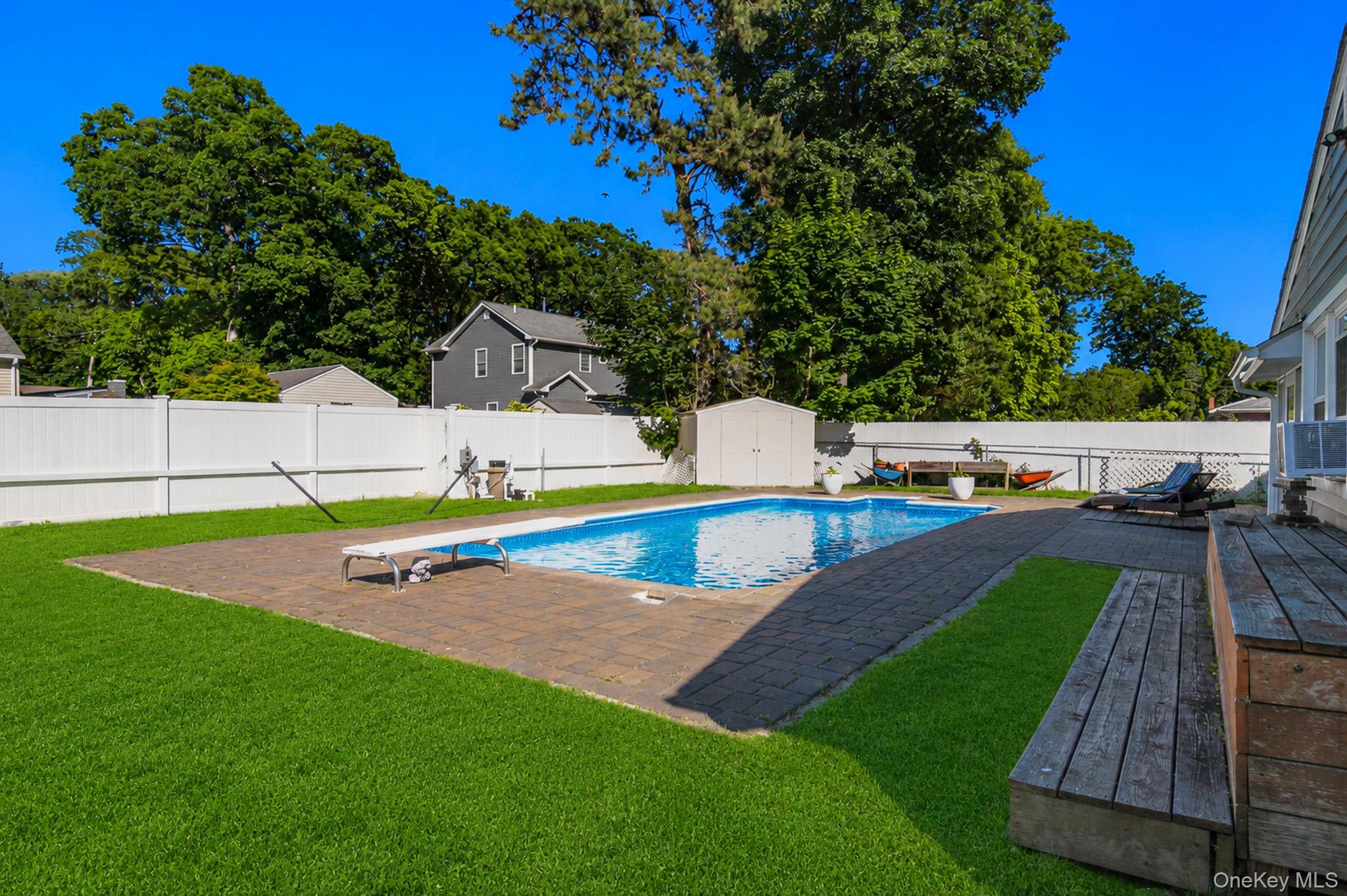 33 Lillian Road Nesconset, NY 11767 - Photo 30 of 42 The Spectacular Entertainer's Backyard Offers A Saltwater In Ground Pool With A Diving Board, Expansive Paver Patios & Paver Pool Surround, And The Pool Is Always Warm Because Of Constant Direct Sunlight.