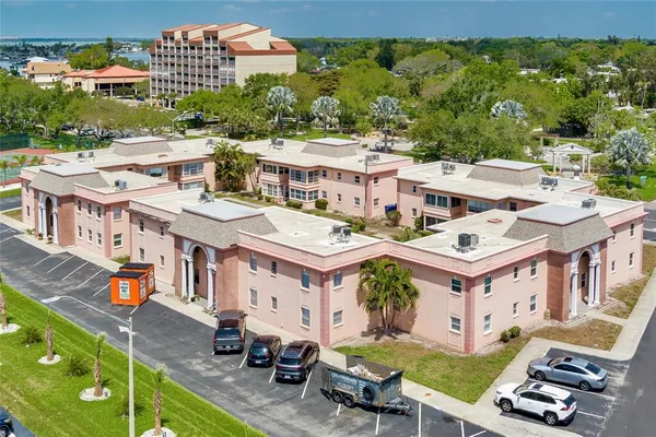 a view of a big building with a big yard plants and large trees