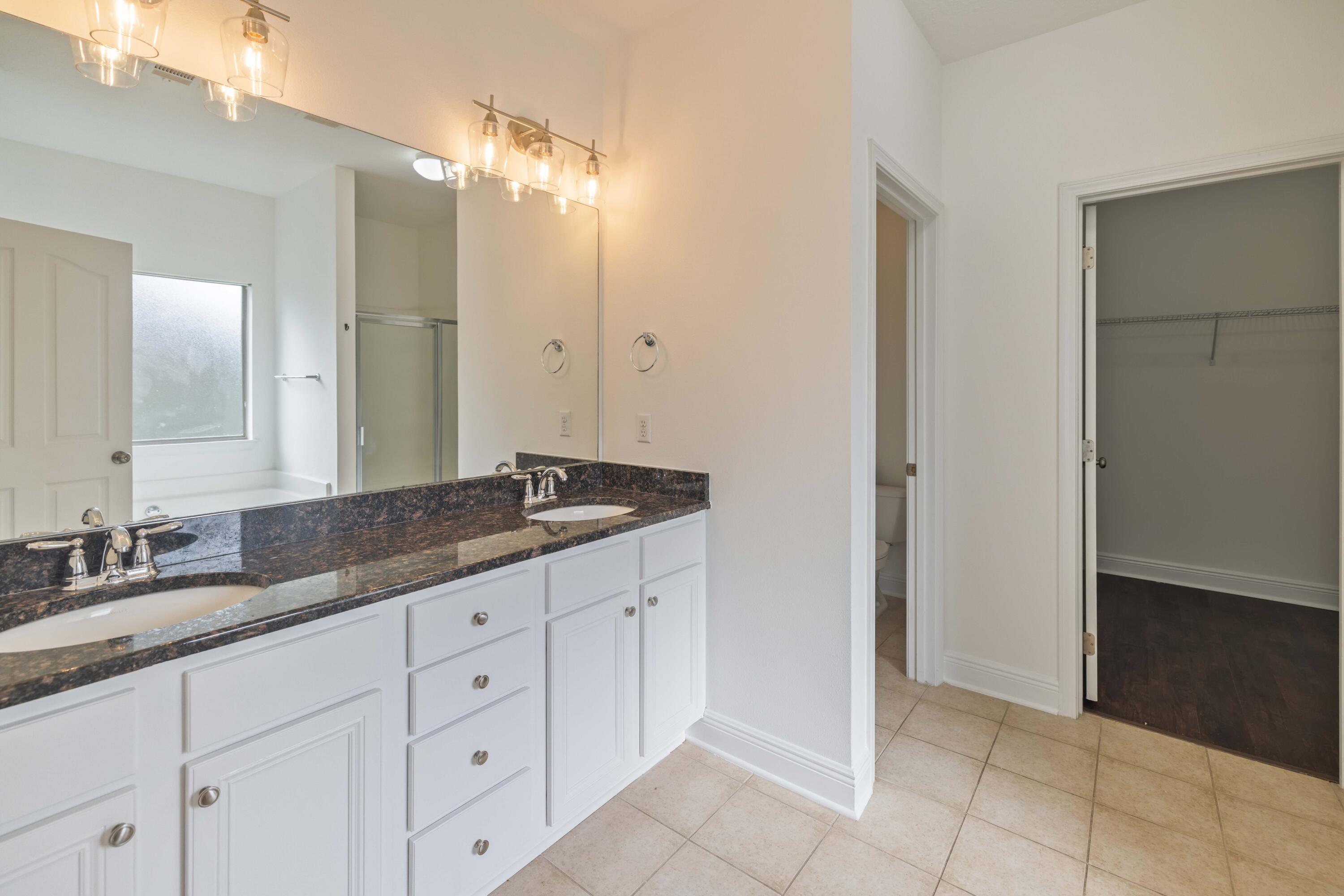 337 Mango Lane Freeport, FL 32439 - Photo 11 of 35 a bathroom with a granite countertop sink and a mirror