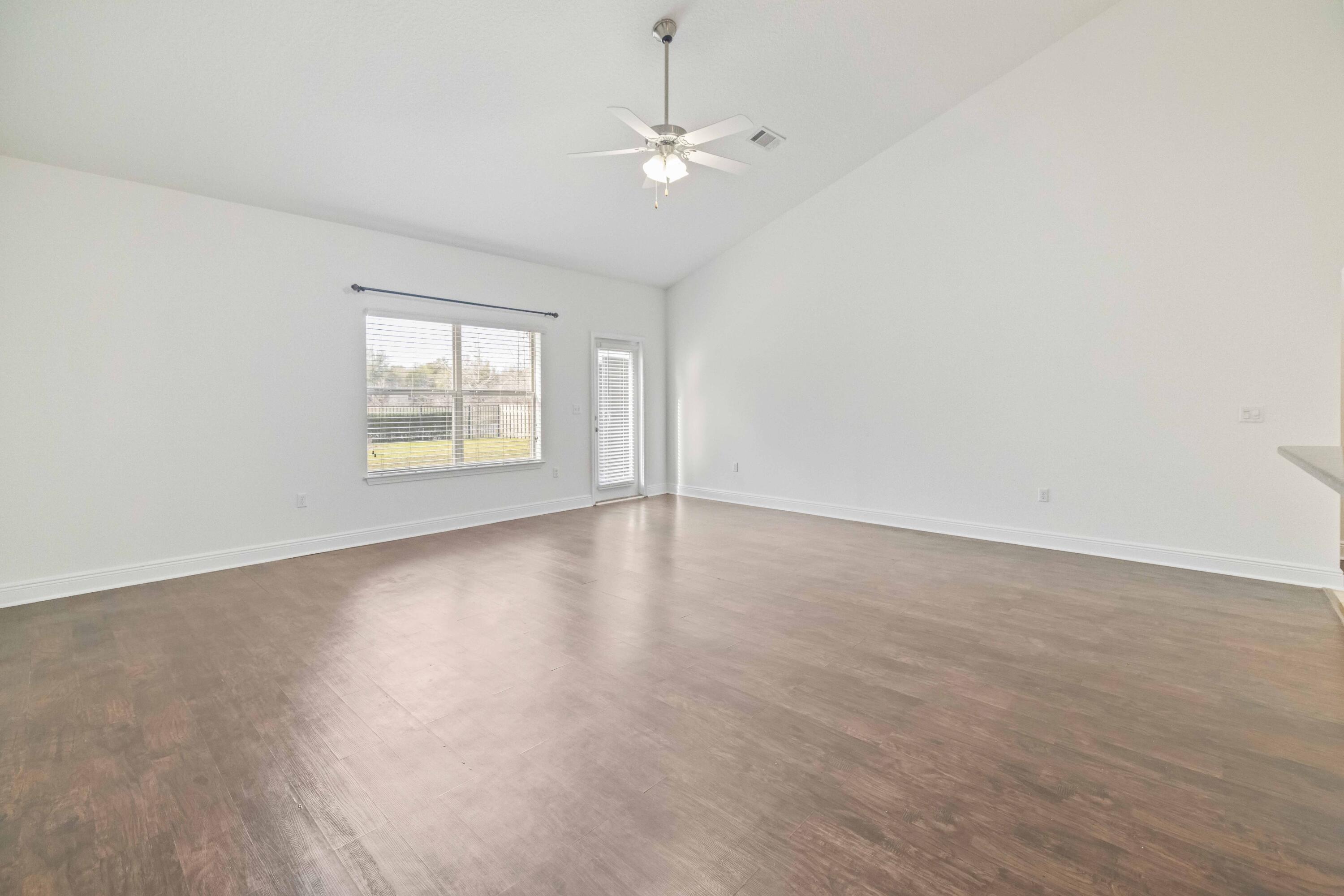 337 Mango Lane Freeport, FL 32439 - Photo 13 of 35 wooden floor in an empty room with a window
