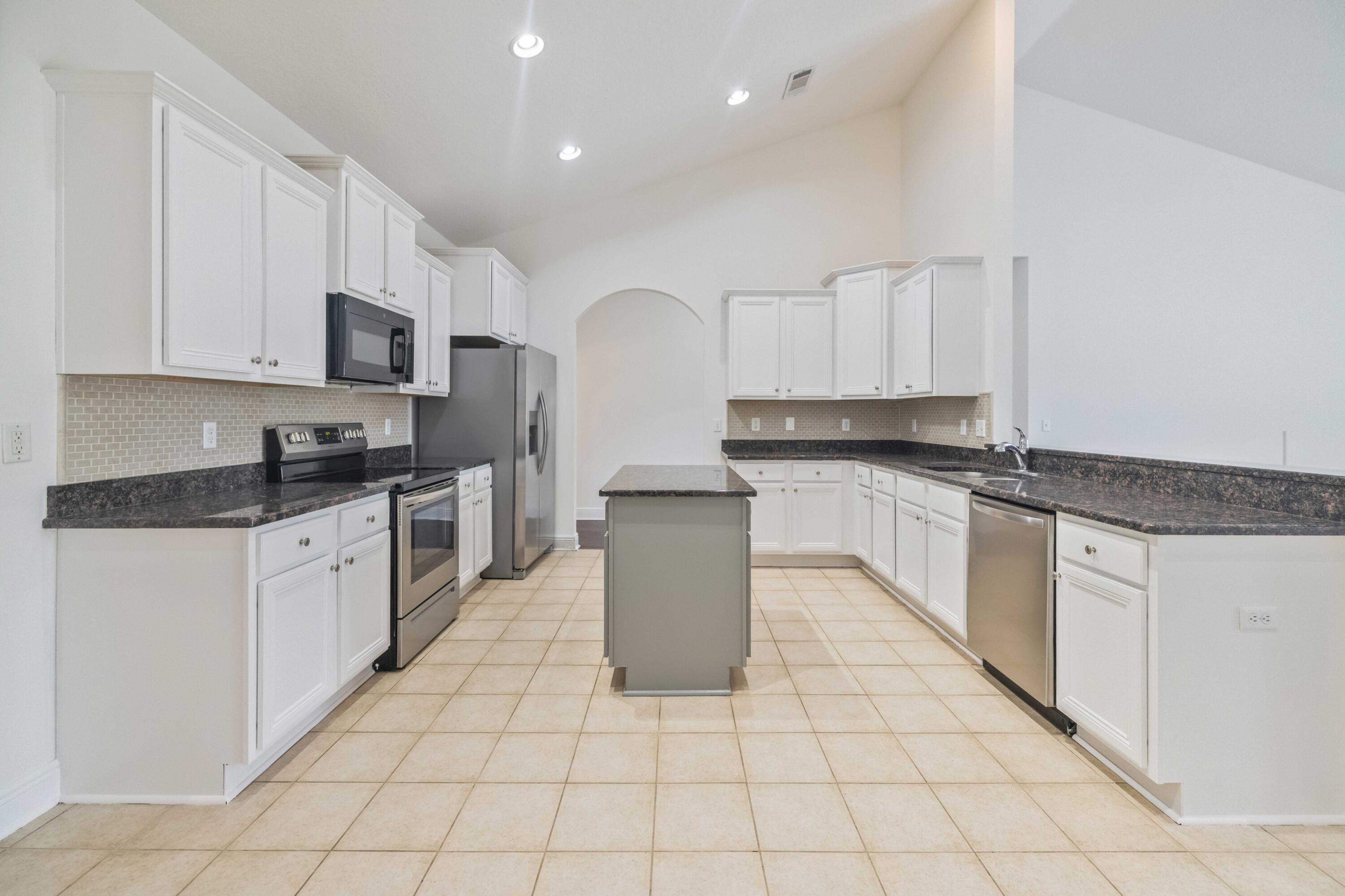 337 Mango Lane Freeport, FL 32439 - Photo 17 of 35 a large kitchen with granite countertop white cabinets and stainless steel appliances
