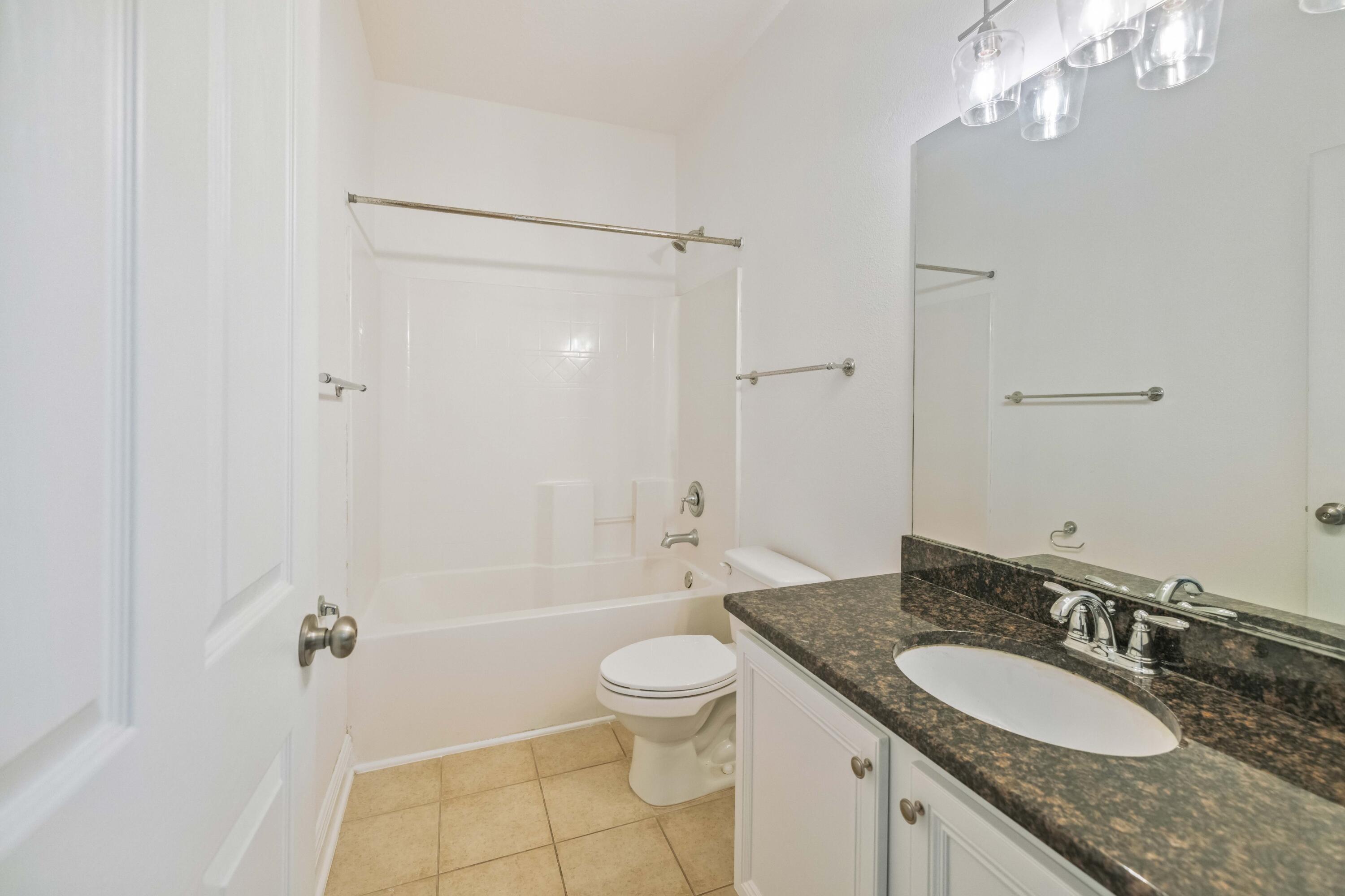 337 Mango Lane Freeport, FL 32439 - Photo 20 of 35 a bathroom with a granite countertop sink a toilet a mirror and shower