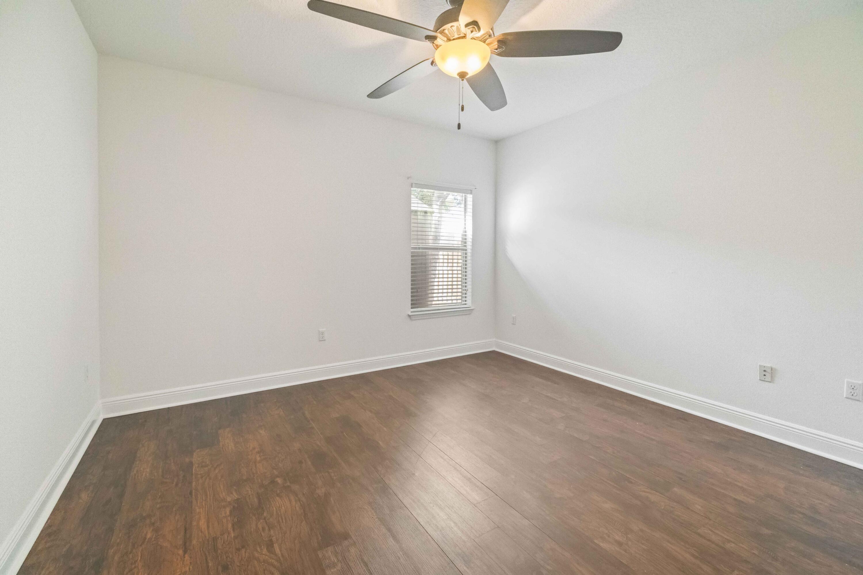 337 Mango Lane Freeport, FL 32439 - Photo 21 of 35 an empty room with wooden floor fan and windows