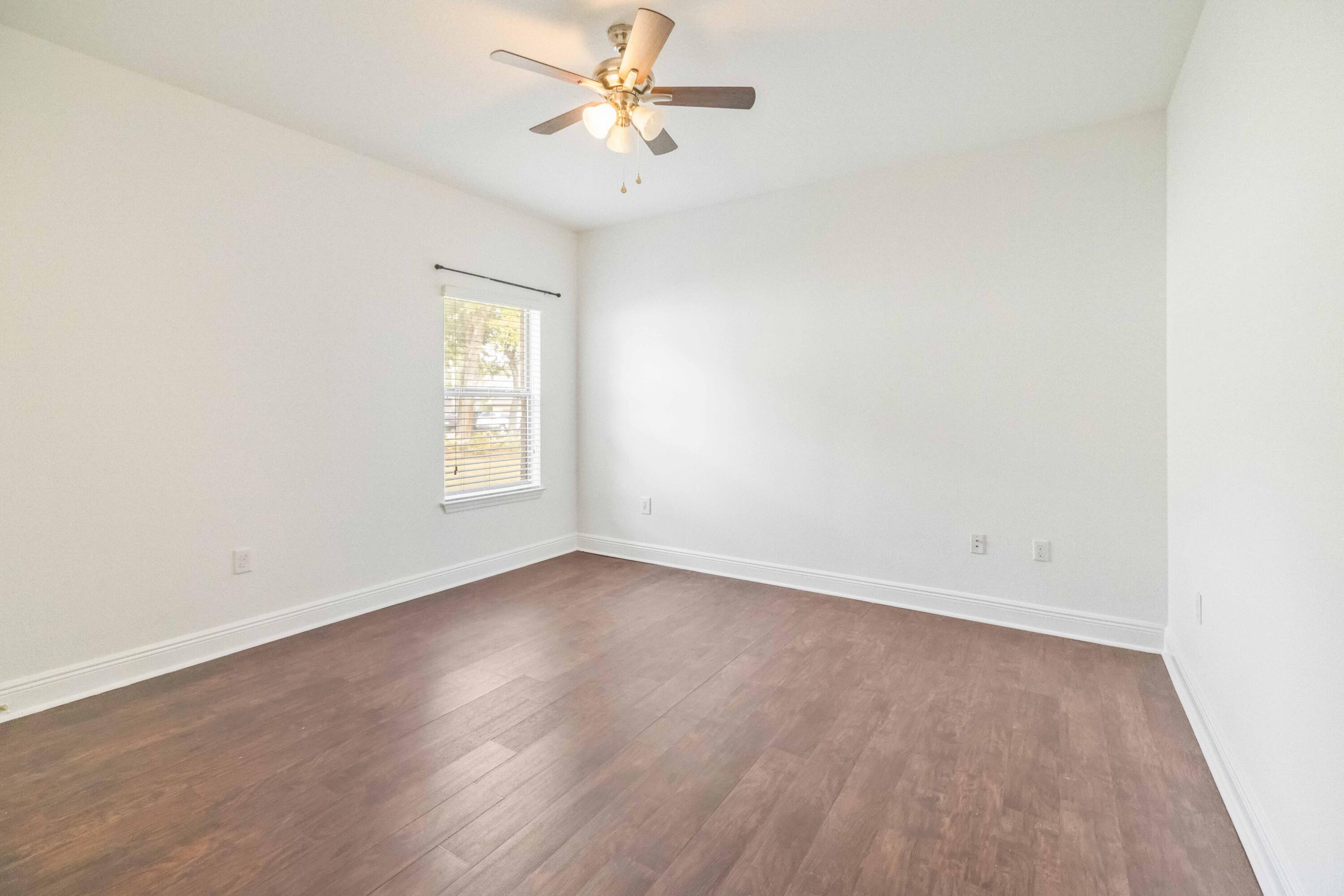 337 Mango Lane Freeport, FL 32439 - Photo 23 of 35 an empty room with wooden floor fan and windows