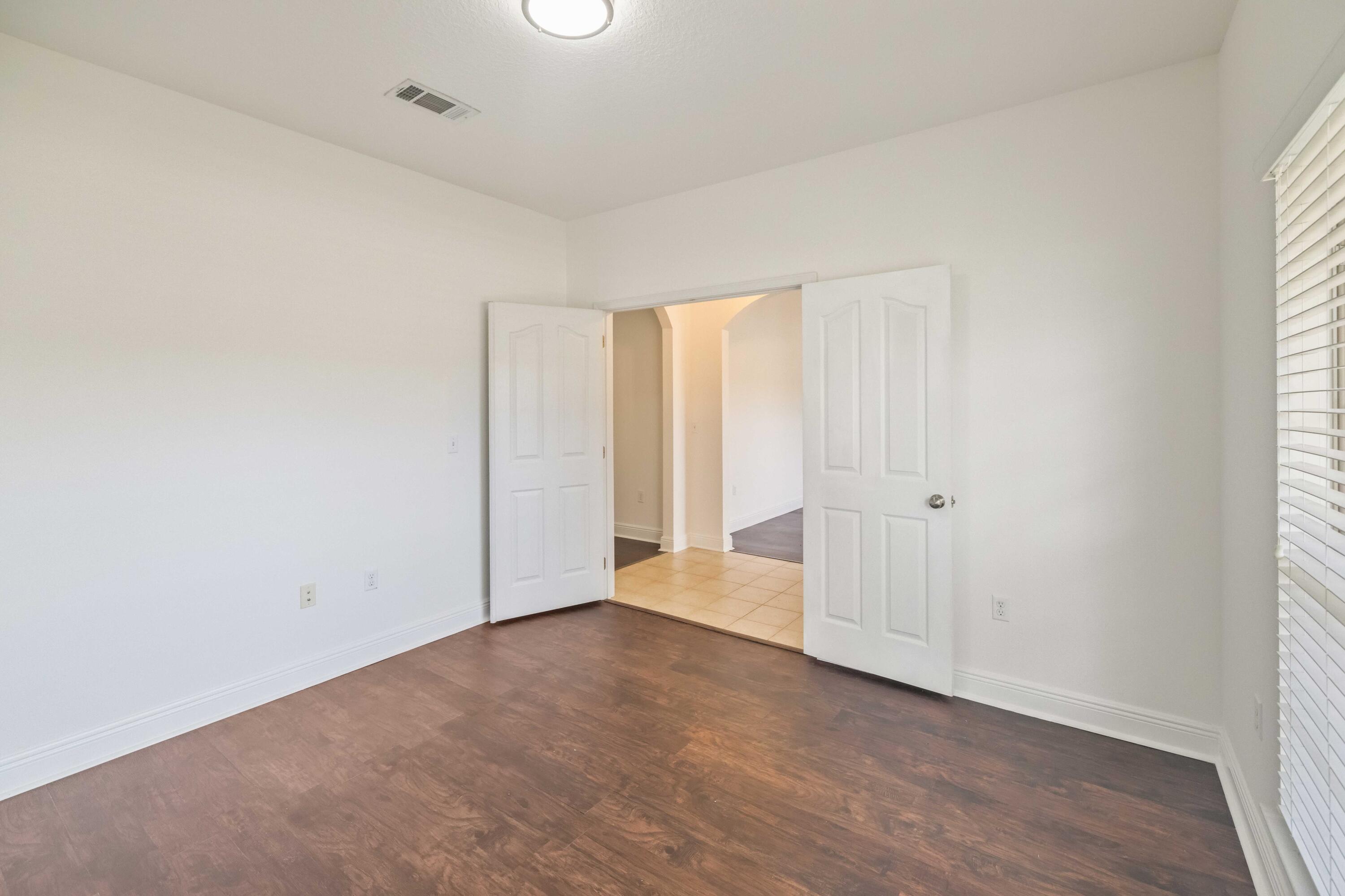337 Mango Lane Freeport, FL 32439 - Photo 7 of 35 an empty room with wooden floor and windows