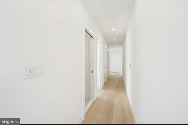 a view of a hallway with wooden floor