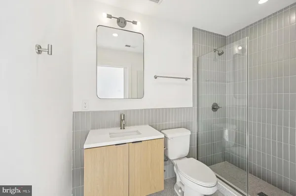 a bathroom with a toilet sink vanity and shower