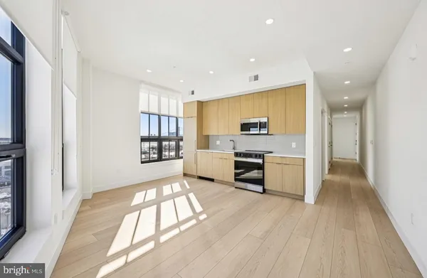 a large white kitchen with stainless steel appliances granite countertop a stove and a refrigerator