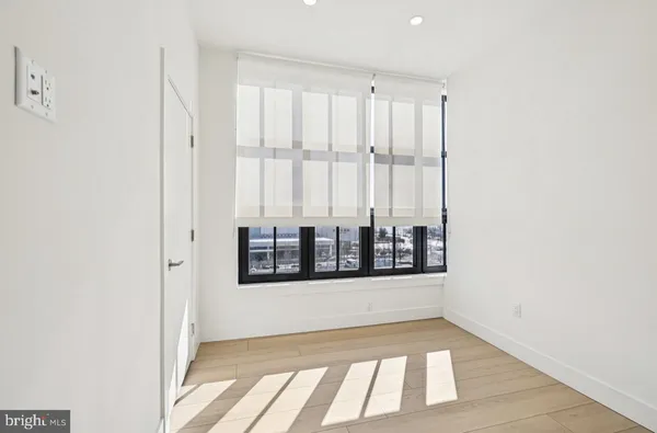a view of a small space with wooden floor and a window