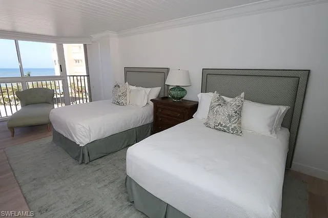 a bedroom with two beds and a large window