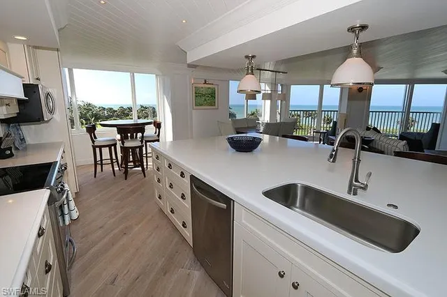 a kitchen with stainless steel appliances granite countertop a sink a stove and a refrigerator