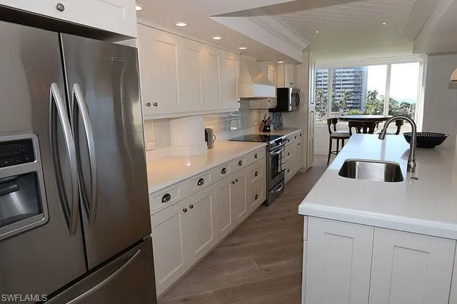 a kitchen with white cabinets and stainless steel appliances