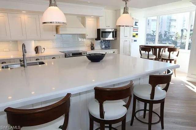 a kitchen with stainless steel appliances a dining table and chairs