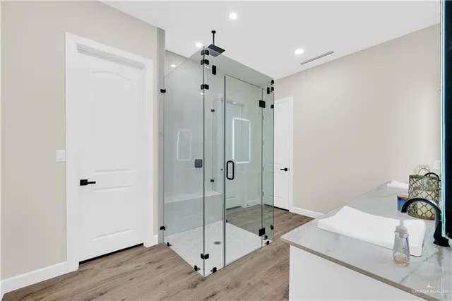 a bathroom with a granite countertop sink mirror and shower