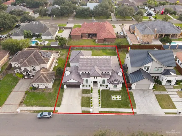 an aerial view of residential houses with outdoor space and parking