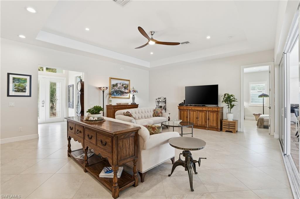 3707 5th Avenue Southwest Naples, FL 34117 - Photo 12 of 45 Living area with a ceiling fan, a tray ceiling, recessed lighting, and light tile patterned floors