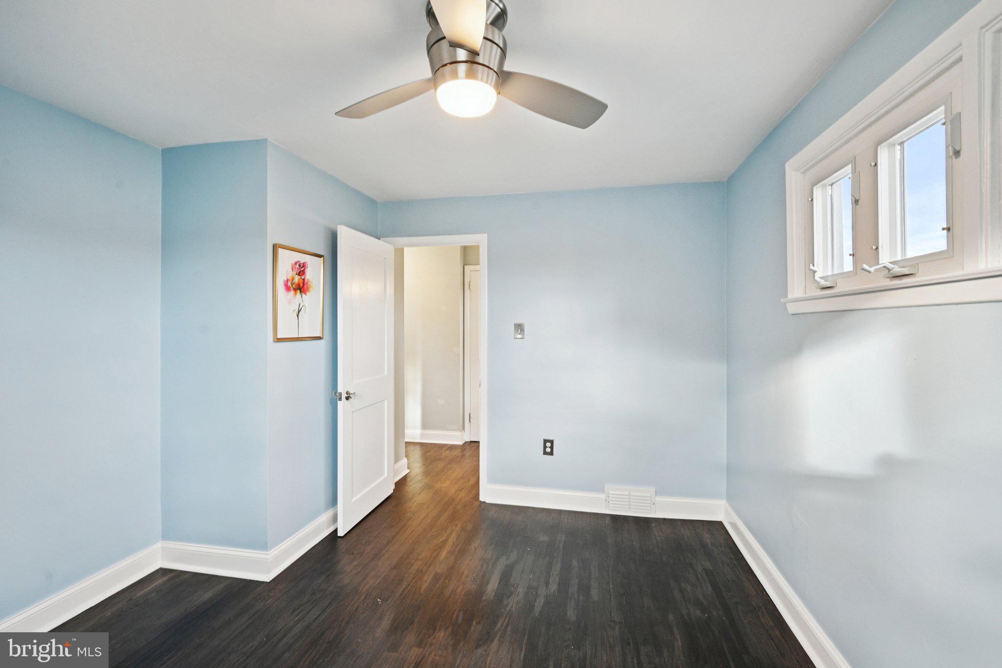 1211 Woodside Road Conshohocken, PA 19428 - Photo 24 of 55 an empty room with wooden floor chandelier fan and windows